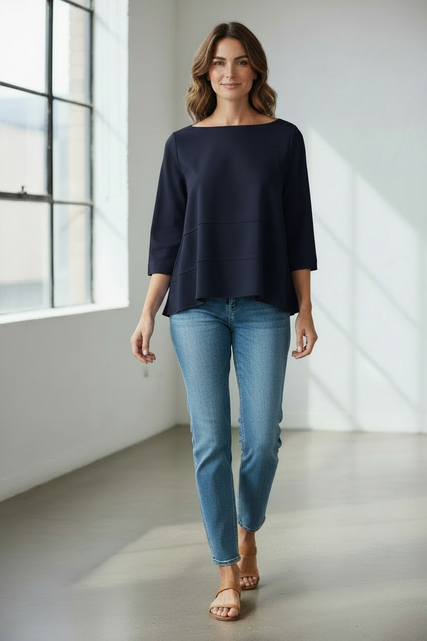 A person wears the MEIMEIJ Oversized Crew Neck Top in bright blue, featuring horizontal seam details, paired with gray pants, standing against a light textured background.