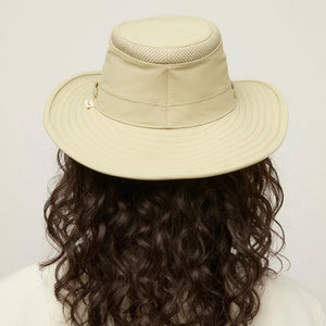 The TILLEY AIRFLO Broad Brim Hat LTM6 in Khaki Olive features mesh ventilation around the crown for outdoor use. Shown on a plain light background, this wide-brimmed sun protection hat is crafted by TILLEY.