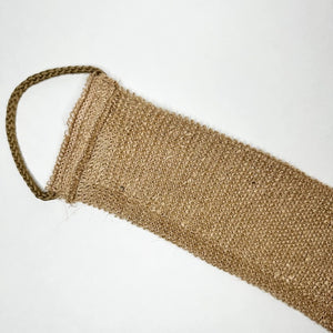 A close-up of the SMILE BOUTIQUES NATURAL ORGANIC JUTE BACK SCRUBBER, featuring a brown, woven jute design with a braided handle at one end and laid flat on a white background—this handmade bath accessory offers a sustainable upgrade to your shower routine.
