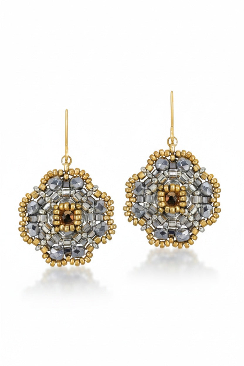 The MIGUEL ASES - MIYUKE CRYSTAL BEAD PYRITE EARRINGS by MIGUEL ASES, INC. showcase a geometrically artistic floral design with Miyuki crystal beading and a central gold bead, suspended from gold hooks and highlighted with subtle silver accents.