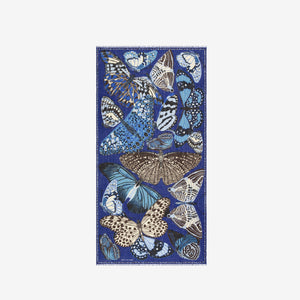 The INOUI EDITIONS - PAPILLON SCARF IN NAVY by INOUI showcases a hand-printed butterfly pattern in blue, white, and tan on navy linen, adding an elegant touch to any outfit.