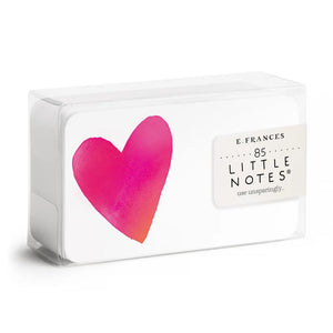A clear box contains 85 tiny notecards each featuring a pink heart, labeled "E. FRANCES PAPER - BIG HEART LITTLE NOTES." With the tagline "use unsparingly," this minimalistic packaging enhances its unique charm.