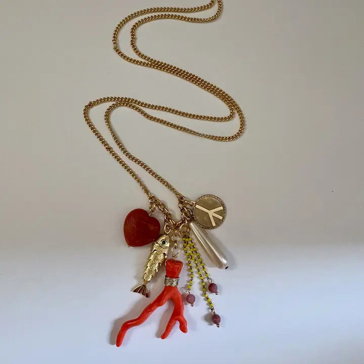 The SANDRINE FRANCE STUDIO SPLASH NECKLACE is a handmade gold chain necklace from NYC, featuring a long cluster pendant with assorted charms—all displayed on a white background.