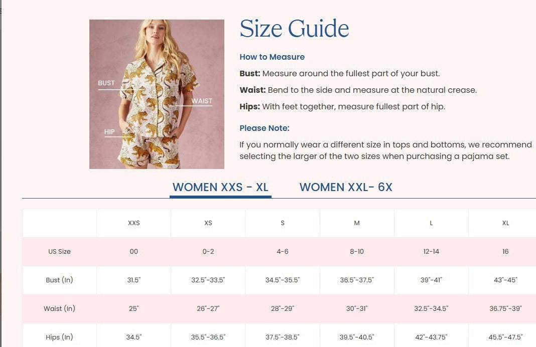 A woman stands barefoot indoors against a white paneled wall, gazing at the camera with a relaxed expression while wearing the PRINTFRESH - BAGHEERA ECO SATIN CHIC TO SLEEP NIGHTIE IN INK by PRINTFRESH, a spaghetti strap maxi nightie crafted from eco-friendly viscose satin and featuring a cheetah and foliage Bagheera print.