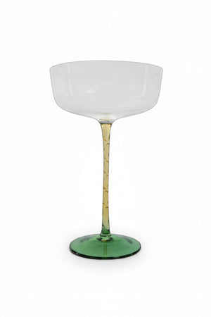 Four VICENZA GREEN AND AMBER COCKTAIL/MARTINI GLASS 325 ml soda-lime drinking glasses with amber stems and green bases on a metal tray, accompanied by two glass spheres with amber and green accents.