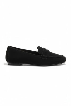 The REQINS HEMA Suede Loafer in Noir features a classic black silhouette, low heel, leather insole, and decorative front strap, shown against a plain light background.