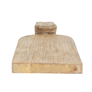 The CREATIVE COOP HAND-CARVED MANGO WOOD CHARCUTERIE/CUTTING BOARD WITH FACE HANDLE features a flat, rectangular shape, rounded edges, and rustic grain patterns for a handcrafted look.
