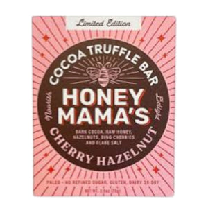 A square package of HONEY MAMA’S - CHERRY HAZELNUT TRUFFLE BAR features a bee graphic with a pink and red design, highlighting it as a limited edition, gluten-free, and dairy-free chocolate bar made with Bing cherries and toasted hazelnuts.