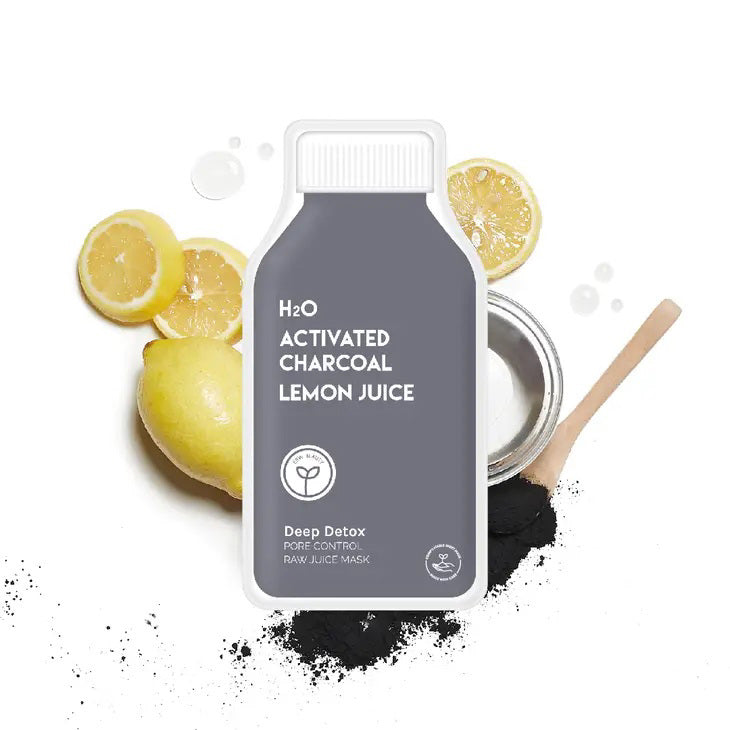 A bottle of ESW BEAUTY - H2O Charcoal Lemon Juice Mask sits on a white surface with lemon halves, a whole lemon, a bowl of white powder, a wooden spoon, and ESW Beauty’s black charcoal powder.