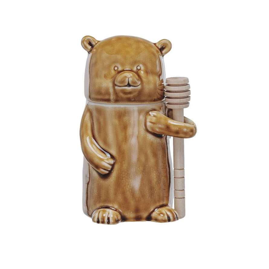 The CREATIVE COOP HONEY JAR WITH WOOD HONEY DIPPER is a ceramic, bear-shaped jar with a glossy brown finish, shown on a white background.