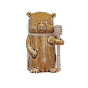 The CREATIVE COOP HONEY JAR WITH WOOD HONEY DIPPER is a ceramic, bear-shaped jar with a glossy brown finish, shown on a white background.