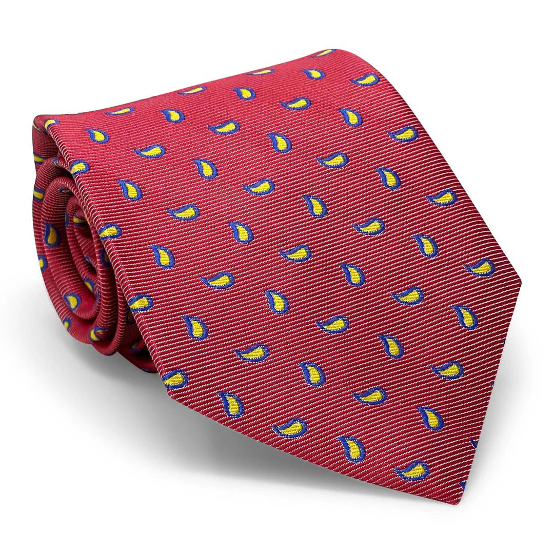 A rolled coral PETER BLAIR - CAPE COD TIE by BIRD DOG BAY, woven silk with a repeating pattern of small blue, yellow, and white sailboats.