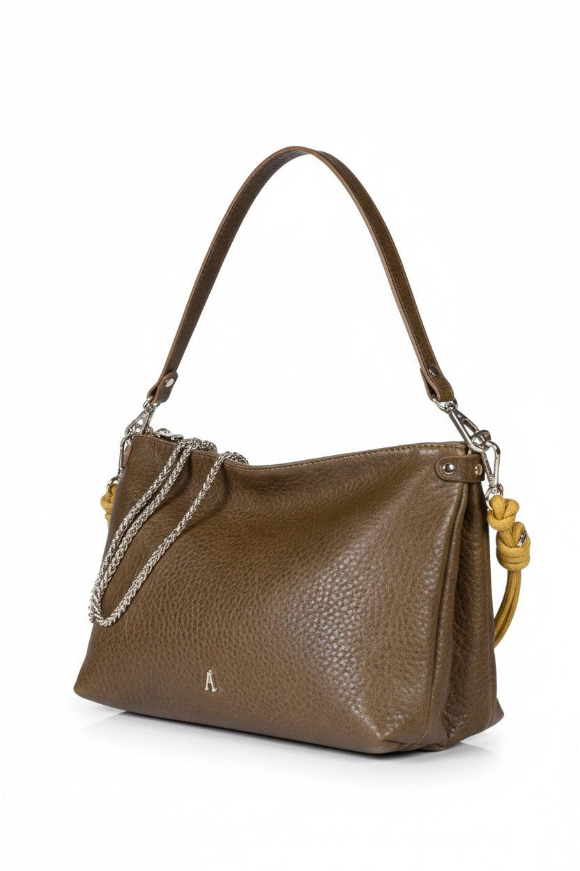 The CRAIE STUDIO DUO BUBBLE UMBER HANDBAG features brown textured vegetable tanned leather with a shoulder strap, silver chain detail, a small front logo, and yellow knot accents on the sides, displayed against a white background.