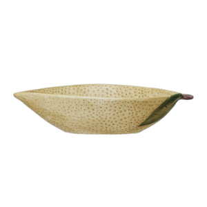 A flat lay features CREATIVE COOP’s HAND-PAINTED STONEWARE LEMON SHAPED BOWL, SMALL—one with oats, one with a grapefruit—plus a lemon-shaped pitcher and ceramic lemons atop a folded striped cloth. A delightful citrus-themed display.