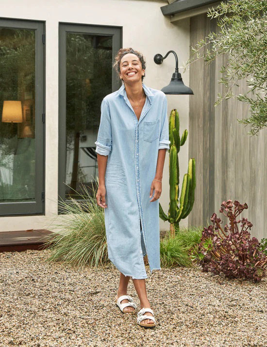 The FRANK &amp; EILEEN Rory Maxi Shirtdress in Famous Denim is a full-length button-up dress featuring a collar, rolled-up sleeves to mid-length, and a single chest pocket. Its sleek, minimalist design embodies that California chic look against a plain white textured background.