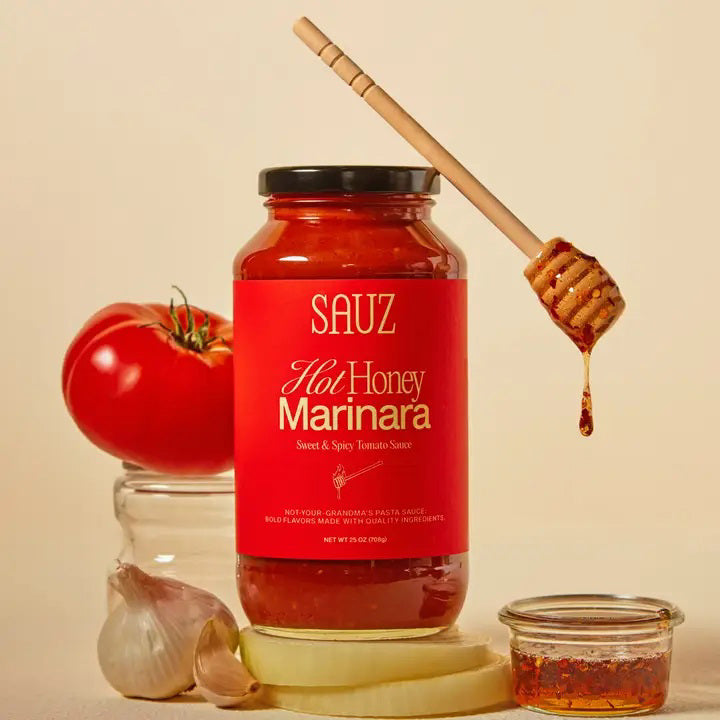 A glass jar of SAUZ - HOT HONEY MARINARA sauce with a red label featuring white text and a honey dipper illustration.