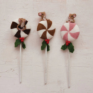 The CREATIVE COOP HANDMADE FELT LOLLIPOP WITH MOUSE features three wool felt lollipops topped with small felt mice, red holly berries, and green leaves in brown/white, tan/white, and pink/white swirls on a light background.