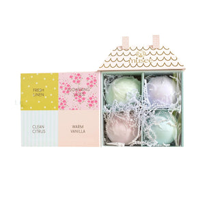 The MUSEE Dollhouse Bath Balm Set by MUSEE features a pastel-colored, house-shaped box with pink doors, six arched windows, gold roof detailing, and charming floral accents. “Anksee” is written in gold above the windows. Perfect as a children’s bath gift, this delightful packaging holds handcrafted natural bath products to make bath time extra special—all set against a light cream background.