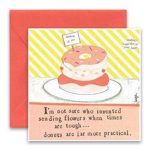 The CURLY GIRL DESIGNS - DONUTS CARD by CURLY GIRL DESIGN, INC features a colorful collage art illustration of donuts stacked on a plate. The top donut has a toothpick flag that reads "thinking of you." Next to it, text reads "sending a bright spot to your heart." Below, it says, "I'm not sure who invented sending flowers when times are tough... donuts are far more practical.