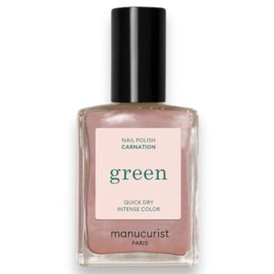 A hand with light pink polished nails holds a bottle of MANUCURIST - GREEN™ Nail Polish in Carnation by MANUCURIST INC, featuring a pearly pink vegan formula and the “green” label, resting against the pocket of light blue denim jeans.