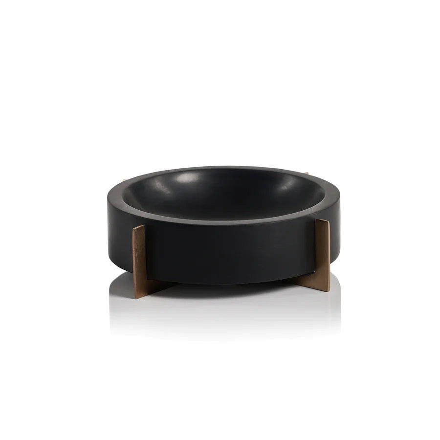 The NAIROBI BLACK MARBLE BOWL by ZODAX features a round, black design with a thick rim and three gold metal legs. Minimalist background accentuates its size: 23.5 cm x 6.35 cm (9.25 in x 2.5 in).