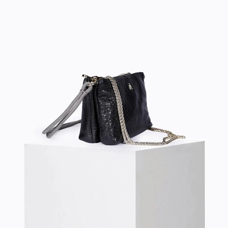The CRAIE STUDIO - DUO BUBBLE NOIR HANDBAG by CRAIE STUDIO is showcased from above on a white background. This luxurious black bubble leather handbag features elegant gold zippers, two spacious compartments, and a gray corded strap. Crafted for both style and practicality, this chic double-zipped pouch perfectly balances fashion and function.