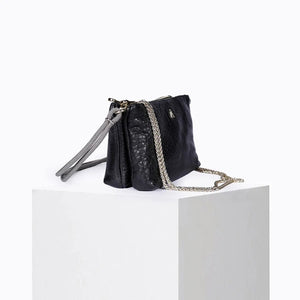The CRAIE STUDIO - DUO BUBBLE NOIR HANDBAG by CRAIE STUDIO is showcased from above on a white background. This luxurious black bubble leather handbag features elegant gold zippers, two spacious compartments, and a gray corded strap. Crafted for both style and practicality, this chic double-zipped pouch perfectly balances fashion and function.