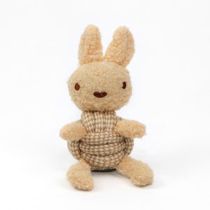 The KNOTTY PAWS - SQUEAKY ROPE BUDDIES by KNOTTY PAWZ is a charming, eco-friendly dog toy. It's a beige, textured plush rabbit with brown stitched eyes and a smiling mouth, seated against a white background. Perfect for delighting your furry friend sustainably.