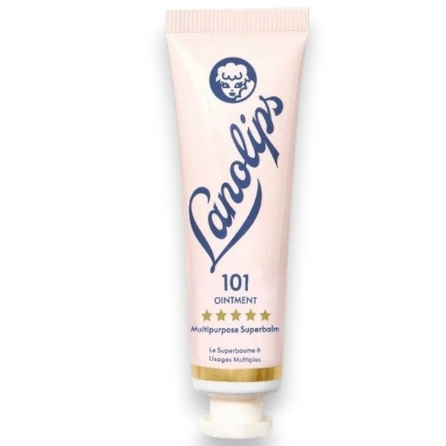 A pink tube labeled “LANOLIPS - 101 OINTMENT MULTIPURPOSE SUPERBALM” from LANOLIPS—an ultra-hydrating moisturizer—displays a blue logo with a sheep’s head and five gold stars, standing upright on a white background.