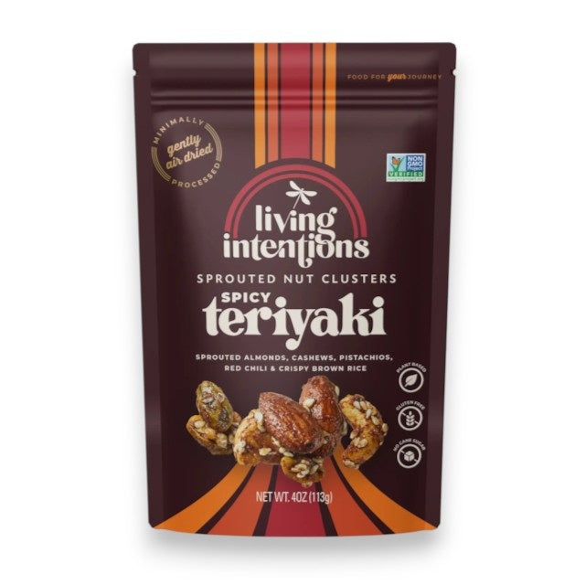 A bag of LIVING INTENTIONS - SUPERFOOD NUT CLUSTERS SPICY TERIYAKI, crafted with sprouted almonds, cashews, pistachios, and crispy brown rice for a bold Spicy Teriyaki blend. The packaging is brown with vibrant orange and red accents, prominently showcasing its Regenerative Organic Certified status.