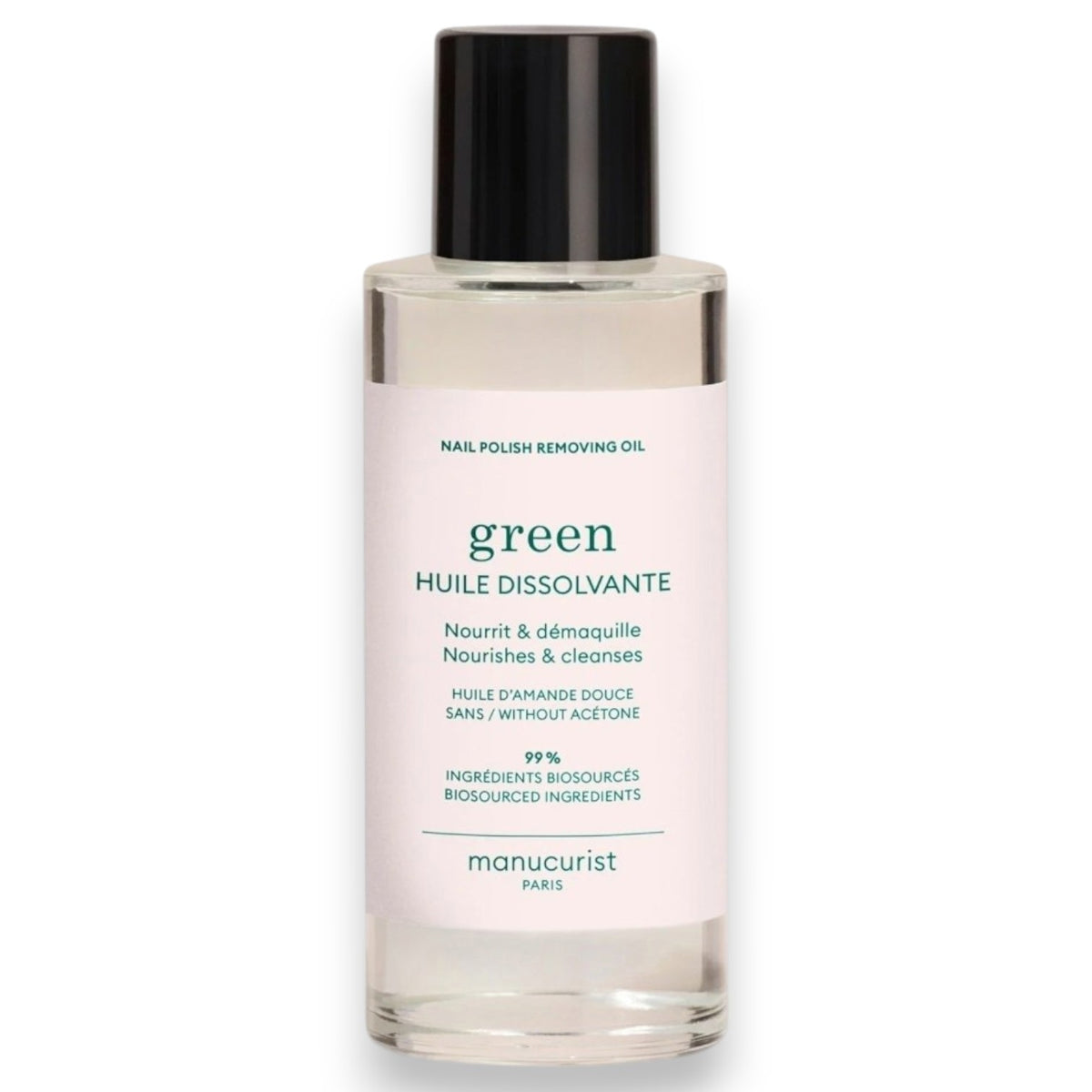 A transparent bottle with a black cap labeled “MANUCURIST - GREEN NAIL POLISH REMOVING OIL” by MANUCURIST INC, described as a gentle, plant-based nail polish remover oil formulated with almond oil, free from acetone, and made with 99% biosourced ingredients.