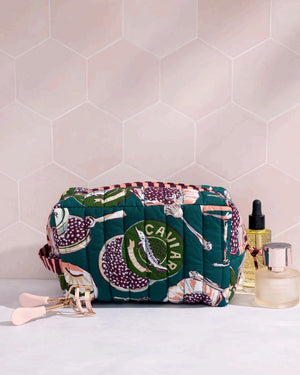 Adorned with an illustrated pattern of caviar tins, open shells brimming with caviar, delicate spoons, and tall champagne glasses on a rich peacock feather green background, the PRINTFRESH - CHAMPAGNE & CAVIAR QUILTED POUCH IN PEACOCK FEATHER is an elegant accessory from PRINTFRESH. This stylish pouch makes a perfect gift for her.