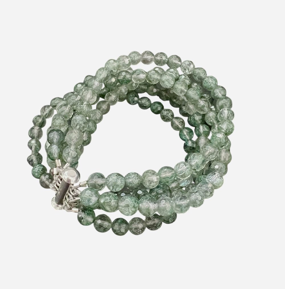 The ANN LIGHTFOOT &quot;Five Strand Green Quartz Bracelet&quot; features coiled, round translucent green beads with a crackled texture, fastened by a stainless steel clasp against a plain white background.