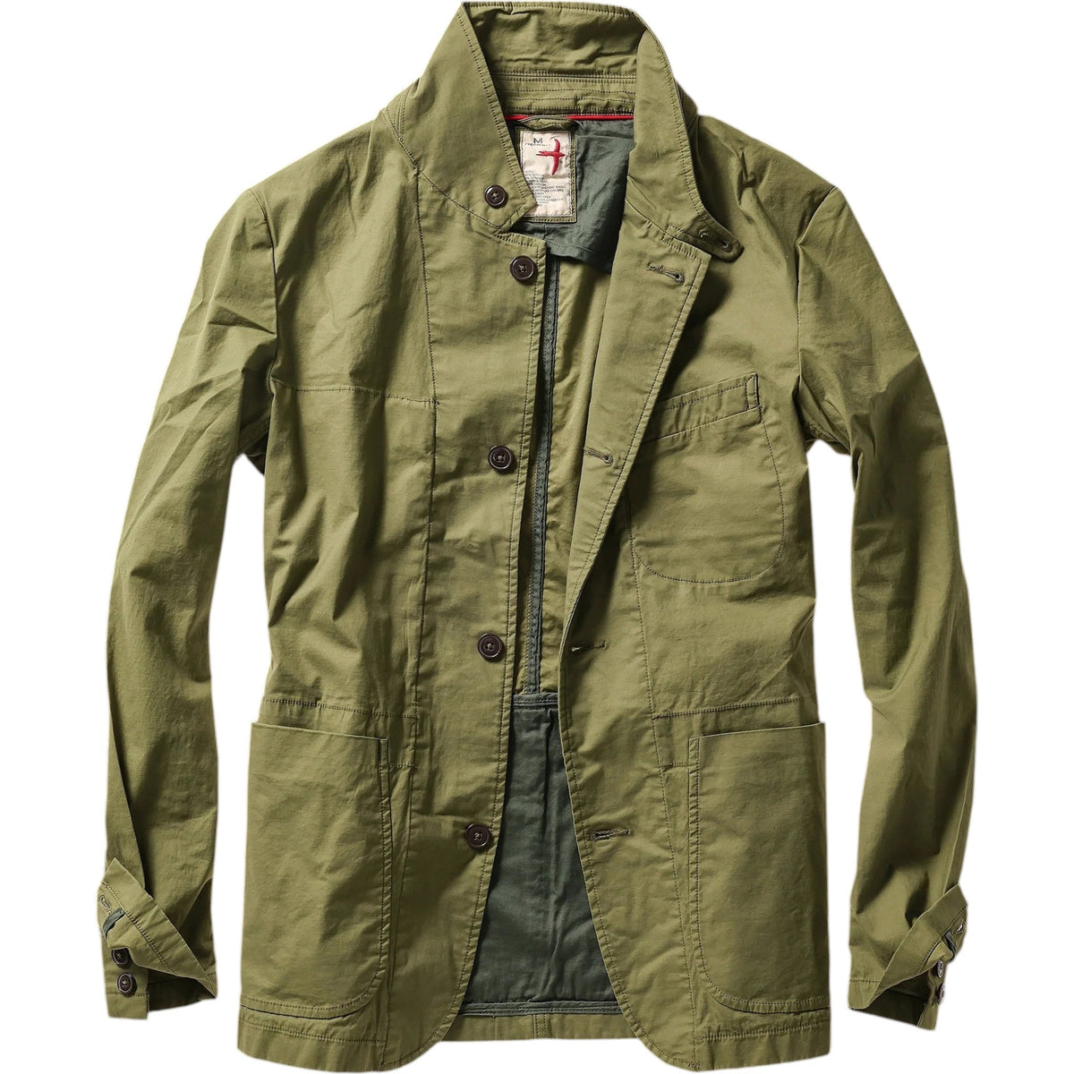 A person models the RELWEN Flyweight Flex Blazer in Burnt Olive over a blue and white checkered shirt with gray pants, hands in pockets, against a plain white background.