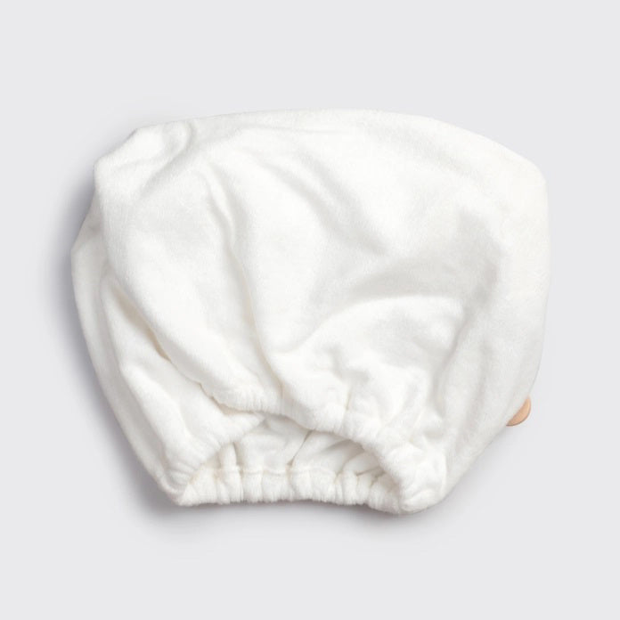 The KITSCH - QUICK DRY HAIR TOWEL, made from organic cotton and bamboo, features eco-friendly packaging with a teardrop design that promises frizz reduction for fine, curly, or straight hair. It includes an image of a person wearing the towel.