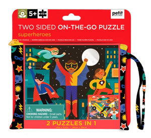 The image shows the packaging of the SUPERHERO DOUBLE SIDED ON THE GO PUZZLE by PETITECOLLAGE, ideal for ages 5+. It contains 49 pieces and is packaged in a vibrant, portable carrying case decorated with heroic characters. Warning: small parts included.