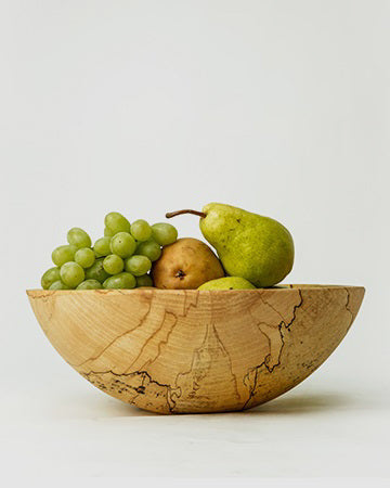 The SPENCER PETERMAN Classic Round Spalted Maple Bowl 18" by PETERMANS BOARDS &amp; BOWLS INC features a handcrafted, smooth, rounded design and unique natural grain patterns, displayed against a plain white background.