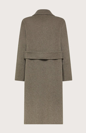 A woman poses confidently with one hand in her pocket, wearing the SEVENTY VENEZIA - WOOL BLEND LONG COAT by SEVENTY over a striped shirt, brown trousers, and brown shoes against a plain background.