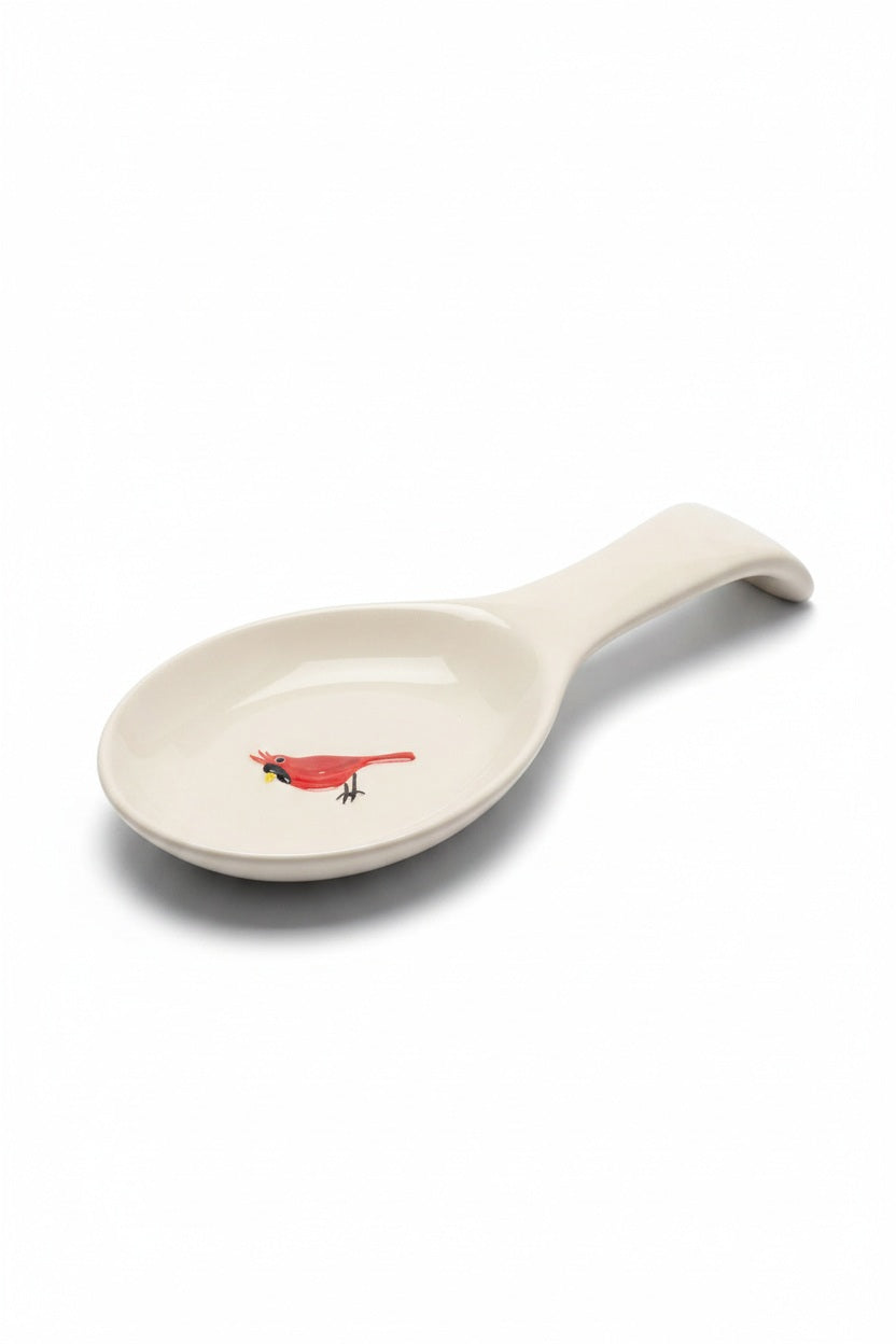 CARDINAL SPOON REST in off-white featuring a small red cardinal illustration in the center, perfect for holiday cooking.