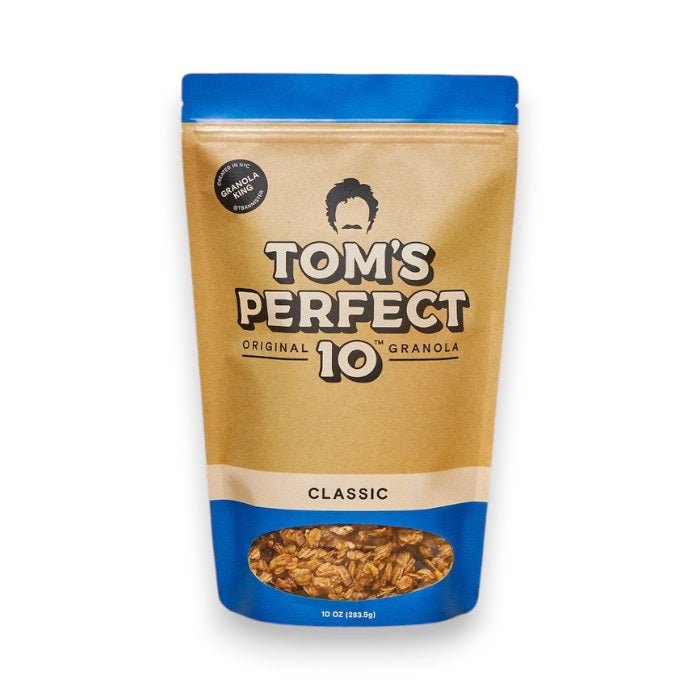 A beige and blue resealable pouch labeled "TOM'S PERFECT 10 - CLASSIC GRANOLA," featuring a transparent window at the bottom displaying the granola inside mixed with cherries. The pouch weighs 10 ounces (283.5 grams). A circular label says "Original Formula.