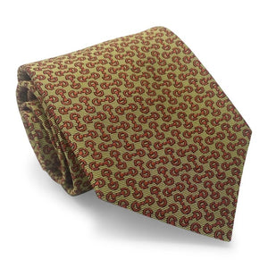 A close-up of the BIRD DOG BAY PETER-BLAIR - HORSEBIT SILK TIE IN YELLOW, featuring a handmade New York woven silk construction with a repeating pattern of small red horseshoes and horse heads on a yellow background. The tie has a pointed tip at the bottom.