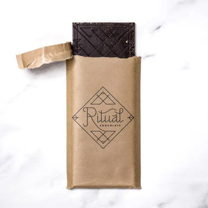 A RITUAL CHOCOLATE - SMORES CHOCOLATE BAR 70% by RITUAL CHOCOLATE, in brown with gold geometric accents and "Graham Cracker and Caramelized Sugar, 70% Cacao" on the label, evokes classic campfire s’mores in every bite.