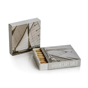 Two ZODAX MATCH BOX - SAILING matchboxes feature a sailboat photo on the cover and “APOTHECARY GUILD” on the side; one open to reveal long decorative matches, ideal for any sailing-themed collection.