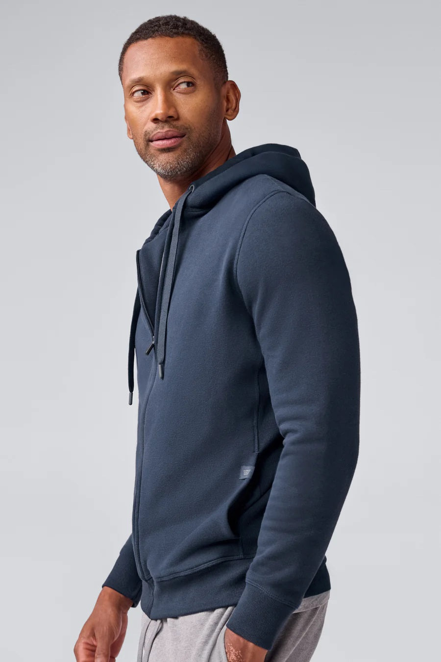The MACK WELDON Ace Full-Zip Sweatshirt in True Navy (Bird’s Eye) is shown flat on a black background, featuring a drawstring hood and long sleeves.