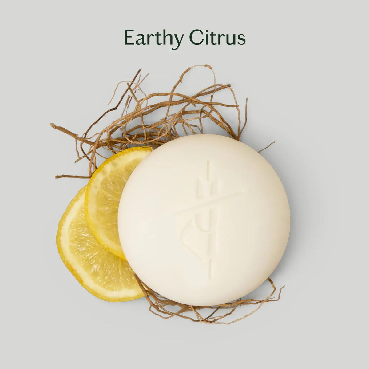 The KATE MCLEOD GROUNDING STONE MINI LOTION BAR 1OZ blends grounding vetiver root and uplifting bergamot lemon to soothe tension and nourish skin, offering a plastic-free skincare solution.