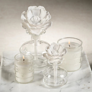 The MINI GRANDCASABLANCA PORCELAIN DIFFUSER - 1.7 OZ by ZODAX features a vintage design with a white flower top and comes in a green leaf-adorned box labeled "Grand Casablanca," filling your space with wild tuberose fragrance.