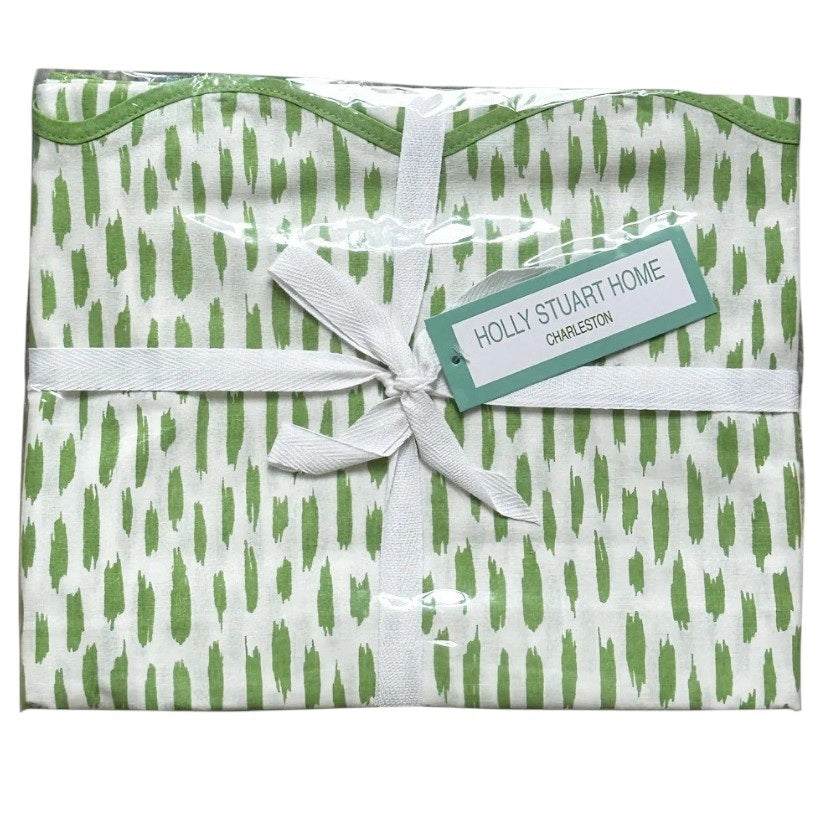 The HOLLY STUART DESIGNS Mahjong and Game Tablecloth in Dash Green Tea features a folded white cotton cloth with a green brushstroke pattern, tied with a white ribbon—perfect for elevating any game or mahjong table.