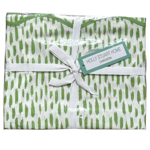 The HOLLY STUART DESIGNS Mahjong and Game Tablecloth in Dash Green Tea features a folded white cotton cloth with a green brushstroke pattern, tied with a white ribbon—perfect for elevating any game or mahjong table.