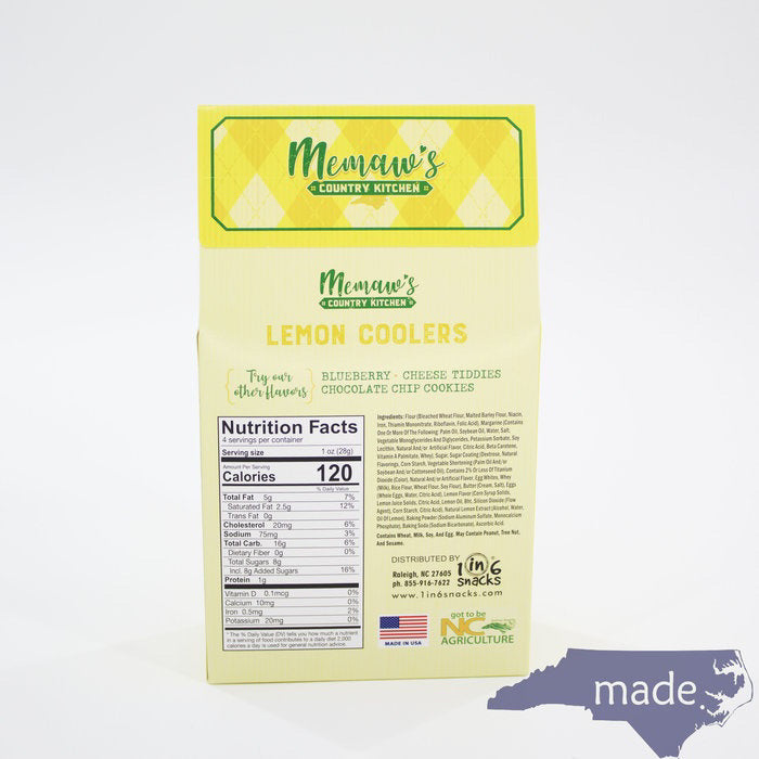 A yellow and green diamond-patterned box labeled "MEMAWS COUNTRY KITCHEN - LEMON COOLERS" from the brand 1 IN 6 SNACKS is pictured. The box displays images of sweet and zesty lemon cookies dusted with sugar. A blue silhouette of North Carolina with the word "made." is in the bottom right corner.