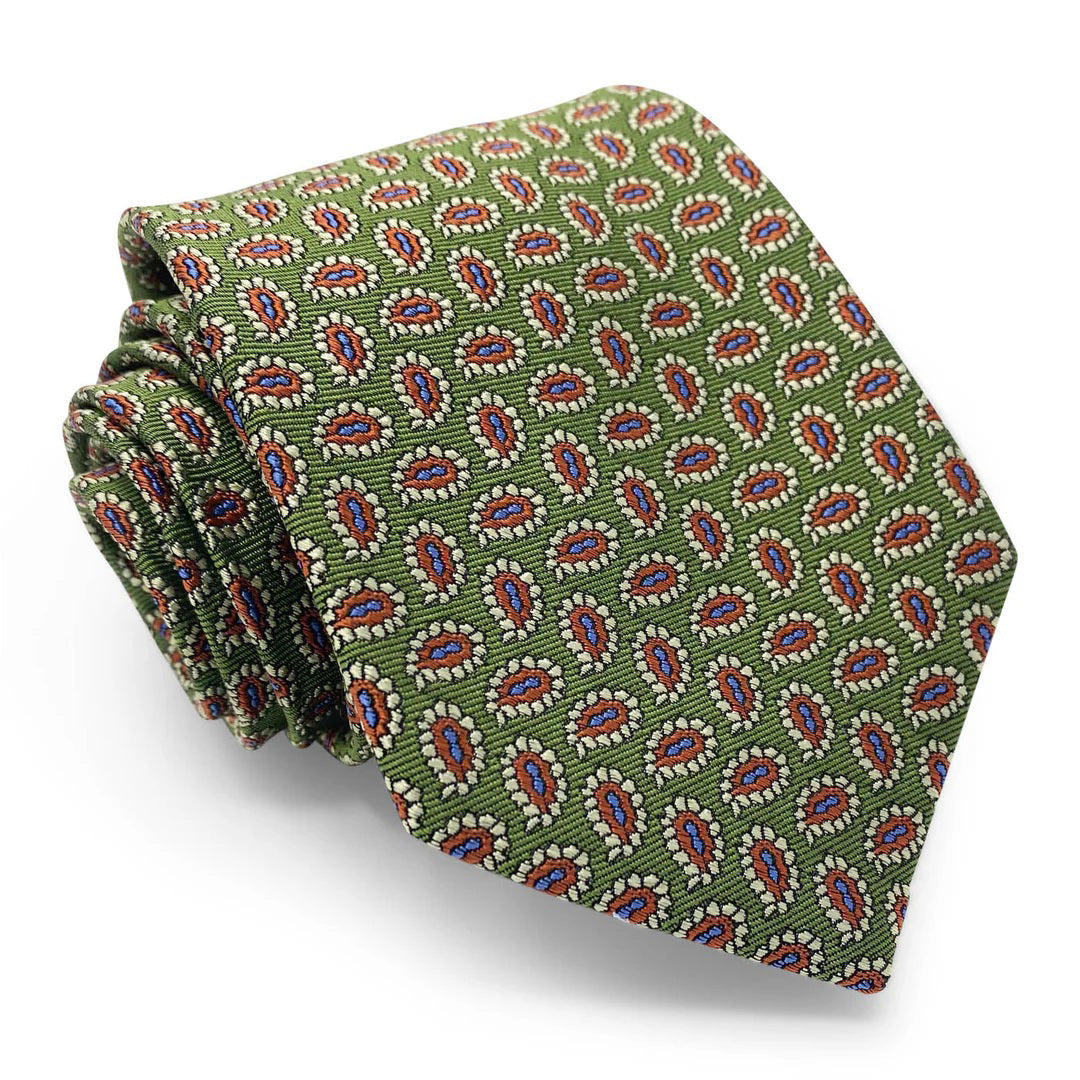 A neatly folded green Primland tie by Bird Dog Bay (Peter Blair), handmade in New York from woven silk, with a repeating red, white, and blue paisley pattern.